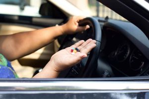 Driver with pills on her hand